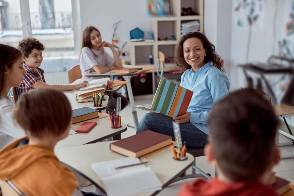 Teacher reading book to classroom of children